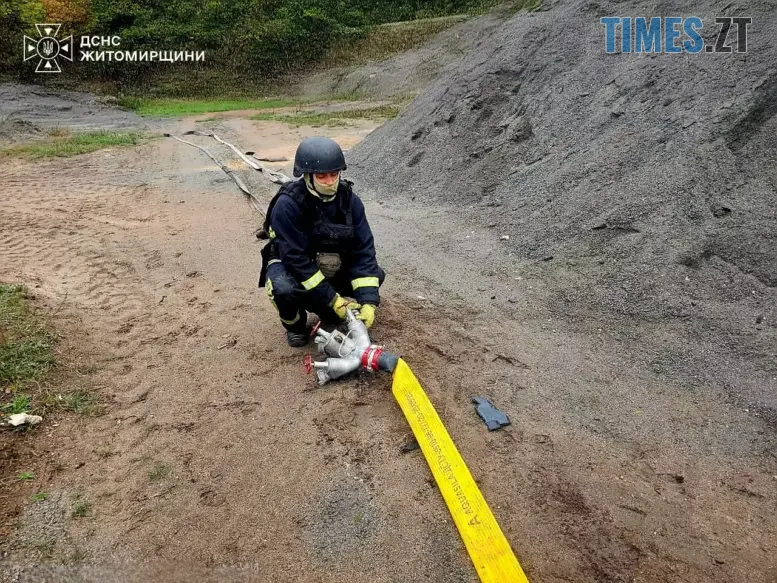 боєць ДСНС розкладає пожежний шланг
