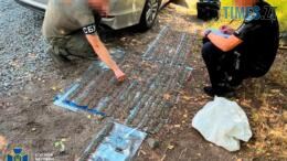 військовий розкладає на землі вилучені у торговця зброєю боєприпаси