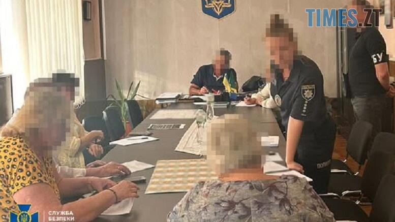 фахівці СБУ сидять за столом з підозрюваними у зловживанні лікарями