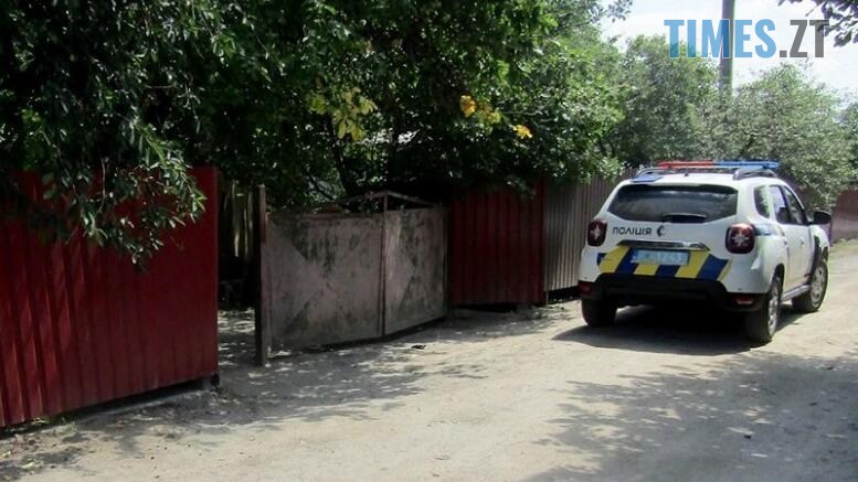 поліцейська машина біля воріт у двір, де стався злочини