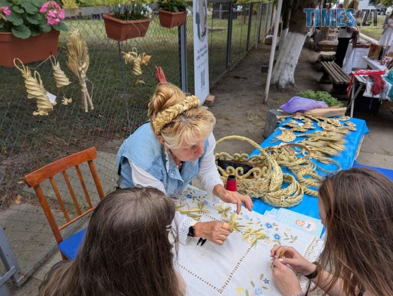 Жінка плете з соломи