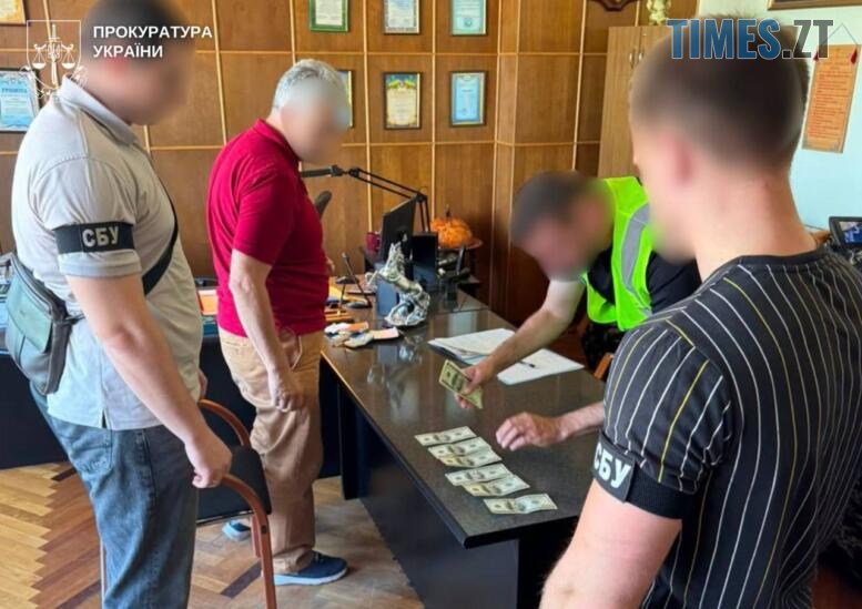 підозрюваний у хабарництві та правоохоронці, один з який розкладає вилучені кошти на столі