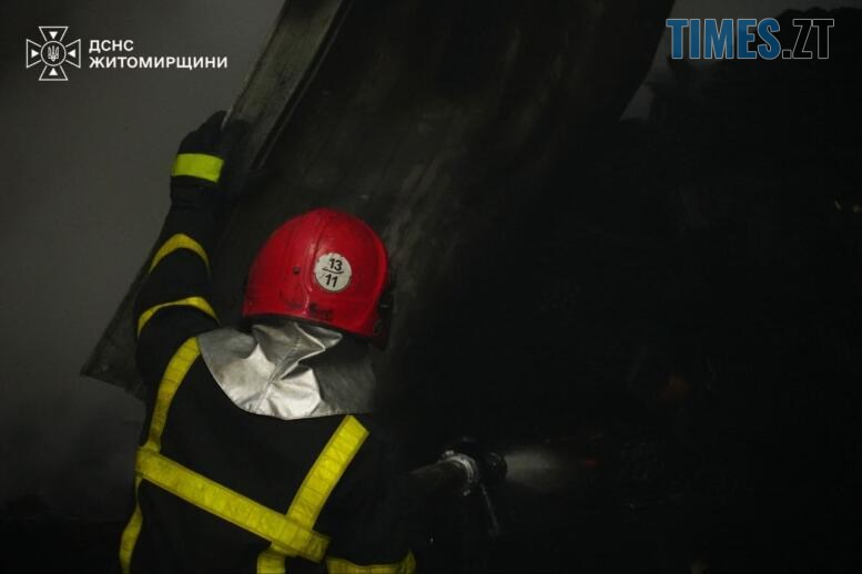 рятувальник гасить пожежу що виникла після удару російських тероритів по підприємству на Житомирщині