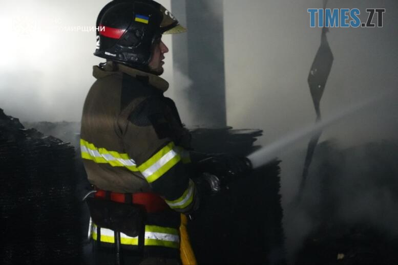 рятувальник гасить пожежу що виникла після удару російських тероритів по підприємству на Житомирщині