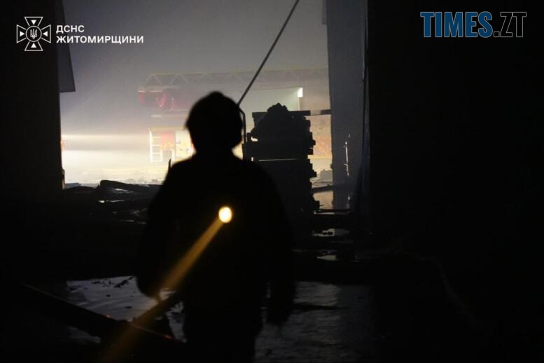 рятувальник гасить пожежу що виникла після удару російських тероритів по підприємству на Житомирщині