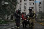 рятувальники несуть постраждало в результаті удару російського дрона по житловому будинку у Києві