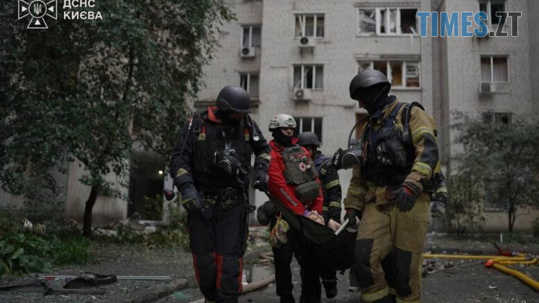 рятувальники несуть постраждало в результаті удару російського дрона по житловому будинку у Києві
