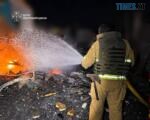 вогнеборець гасить пожежу, що виникла внаслідок удару російського дрона по підприємству на Житомирщині