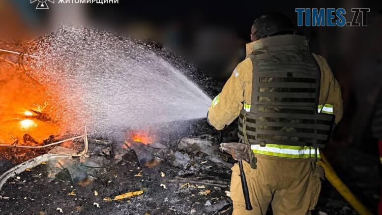 вогнеборець гасить пожежу, що виникла внаслідок удару російського дрона по підприємству на Житомирщині