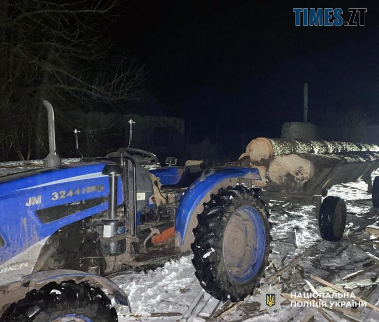 трактор з причепом у якому навантажені колоди
