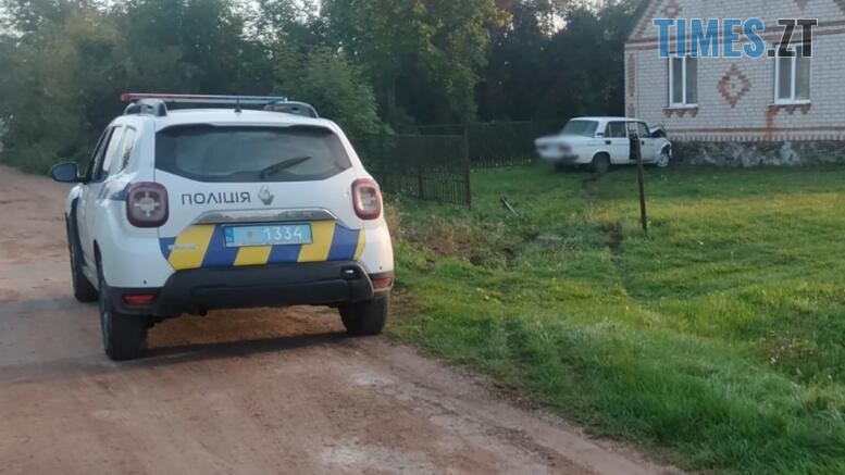 поліцейська машина на фоні якої легковик, що врізався у будинок