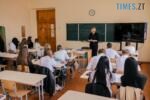 клас, де учні на уроці пишуть та вчителька біля дошки пояснює