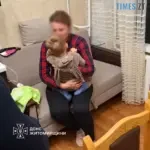 мати тримає на колінах та обіймає сина, який залишився сам у квартирі через замкнені двері