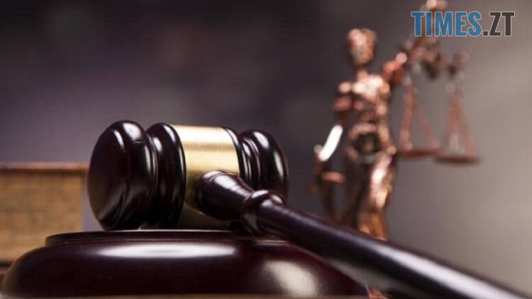 суддівський молоток на фоні фігурки богині Феміди