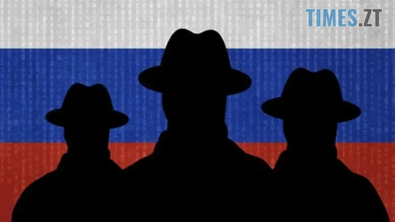 чорні силуети людей в шляпах на фоні російського прапора